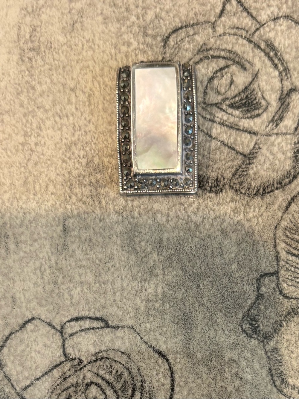 Slider sterling silver pendant , Marquasite stones and mother of pearl center.